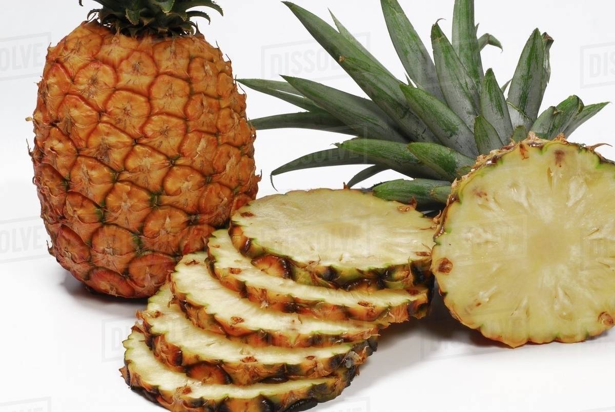 Whole and sliced pineapples Stock Photo Dissolve