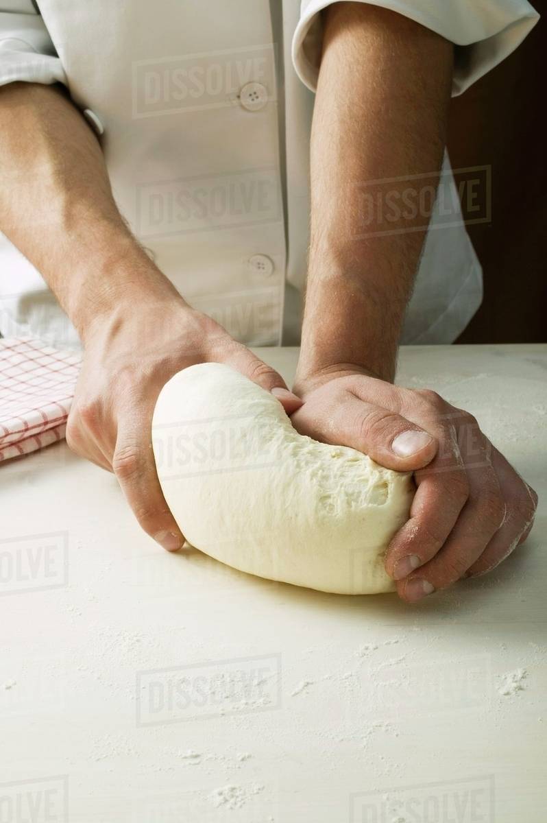 Kneading pizza dough Stock Photo Dissolve