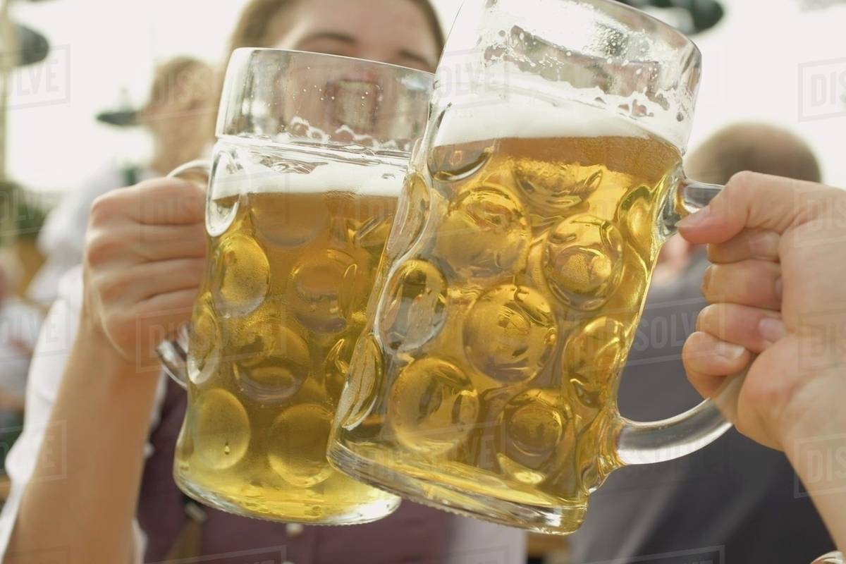 Hands clinking two litres of beer together (Oktoberfest, Munich