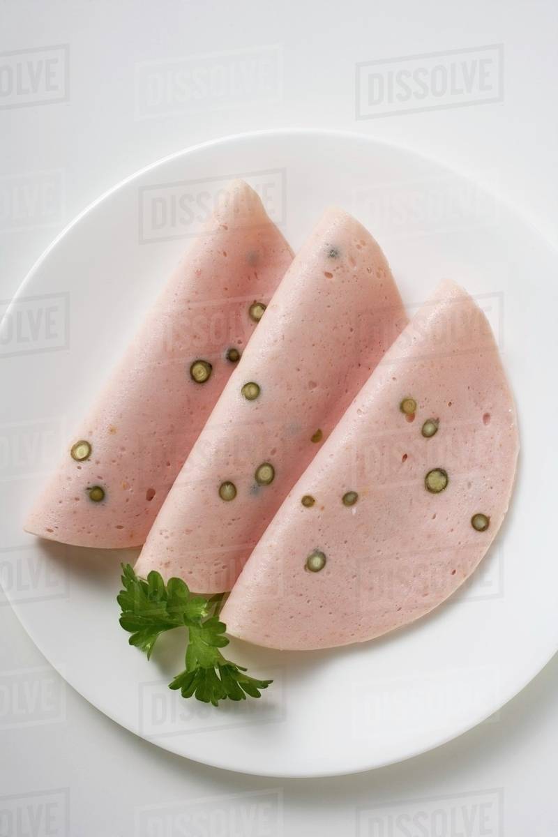 Three slices of Pfefferwurst (pepper sausage) on plate - Stock Photo