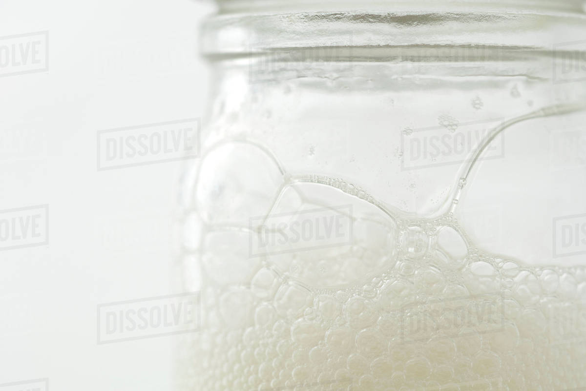 Glass jar with soap suds, extreme closeup Stock Photo Dissolve