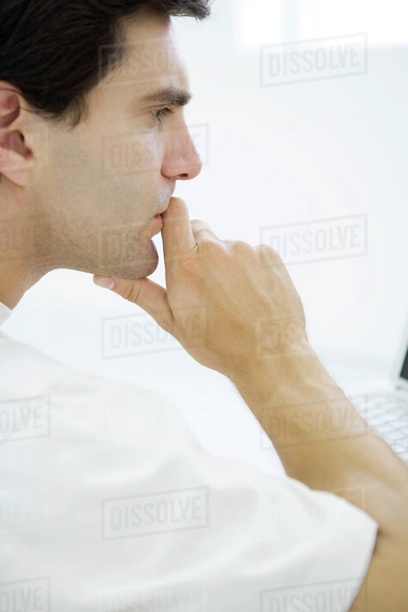 Man holding chin, profile - Stock Photo - Dissolve
