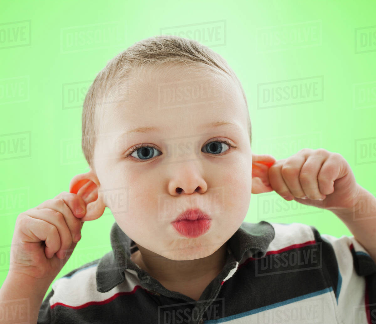 Caucasian boy pulling his ears Stock Photo Dissolve