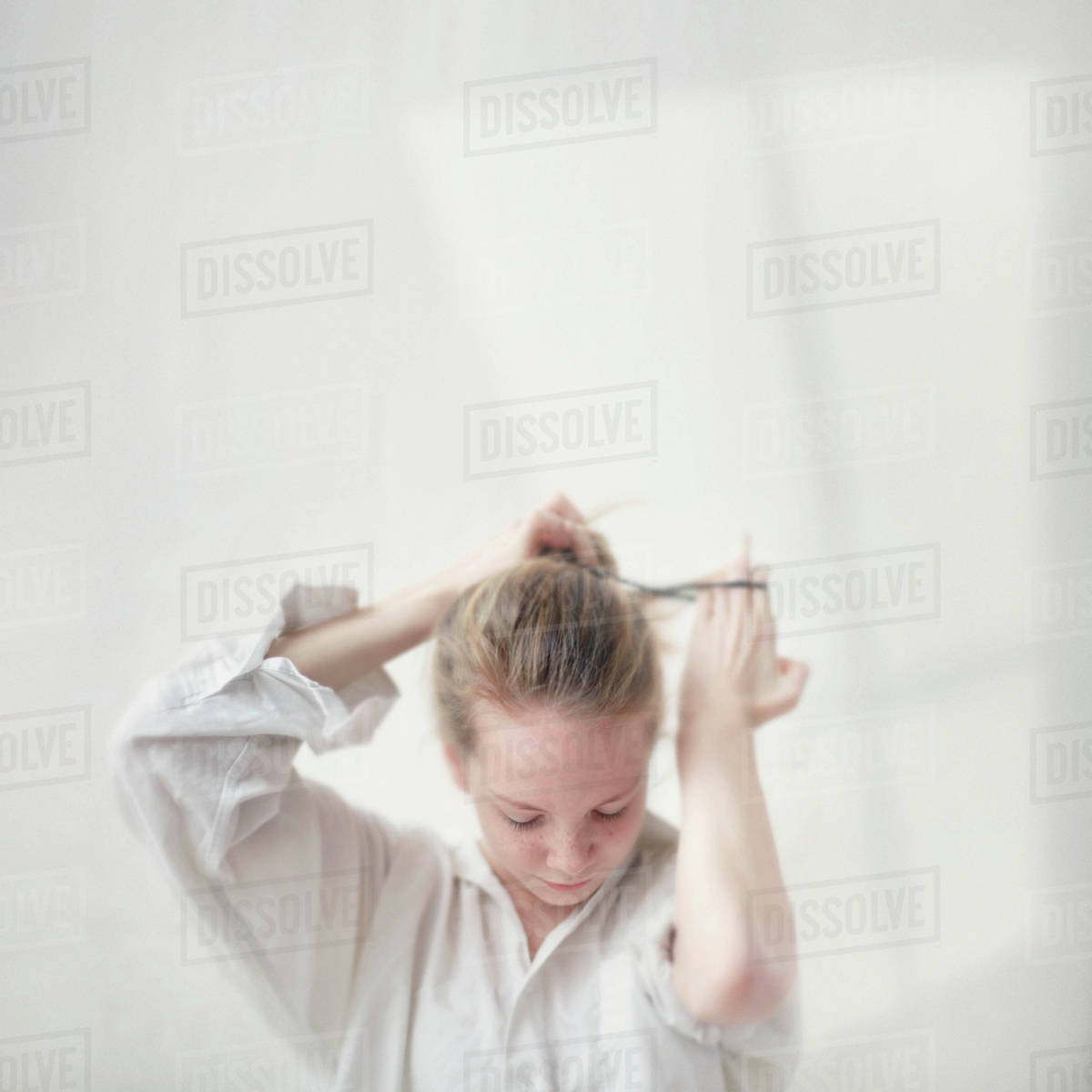 Caucasian Teenage Girl Tying Her Hair Into Bun Stock Photo