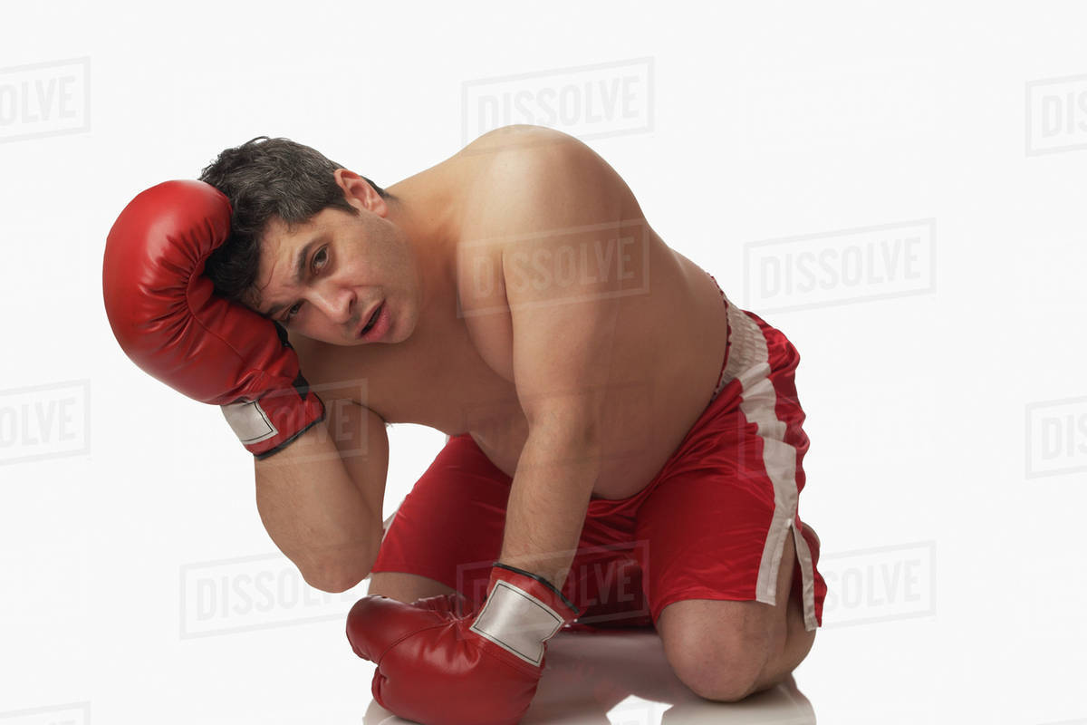 Overweight boxer kneeling on floor Stock Photo Dissolve