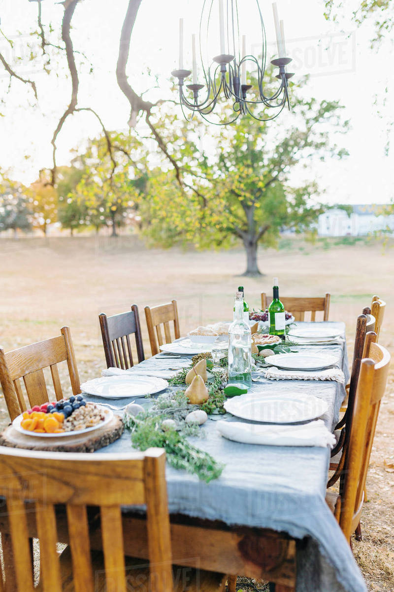 Empty dinner table in field - Stock Photo - Dissolve