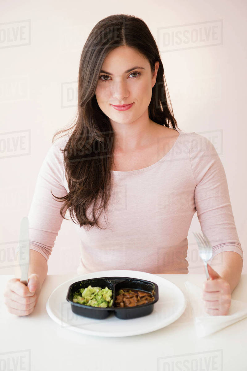 Caucasian woman preparing to eat TV dinner Stock Photo Dissolve