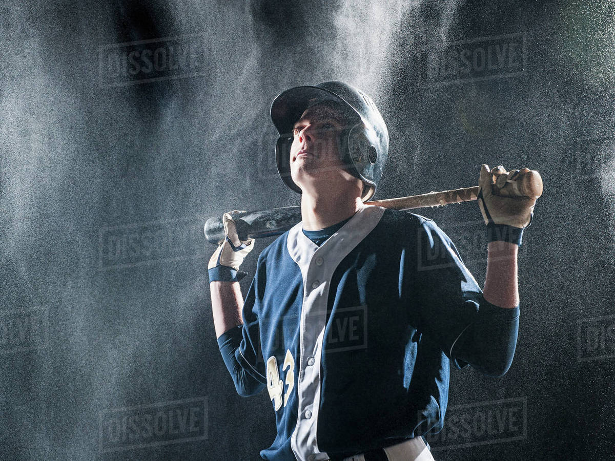 Caucasian baseball player standing in rain Stock Photo Dissolve