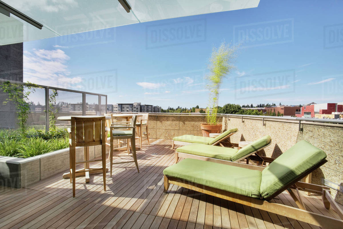 Lounge chairs on rooftop balcony Stock Photo Dissolve