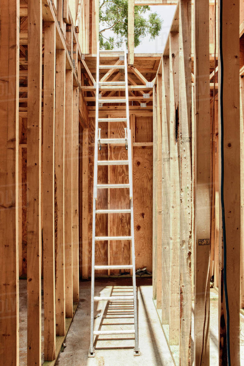 Tall Extension Ladder in an Unfinished Building Stock Photo Dissolve