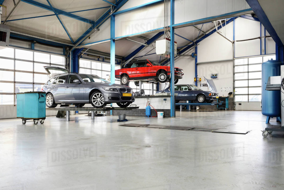 Cars on lifts in auto repair shop Stock Photo Dissolve