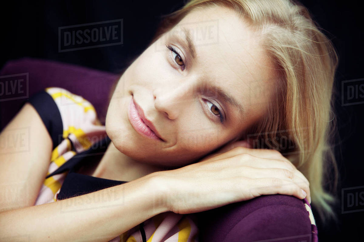 Caucasian woman resting head on chair Stock Photo Dissolve