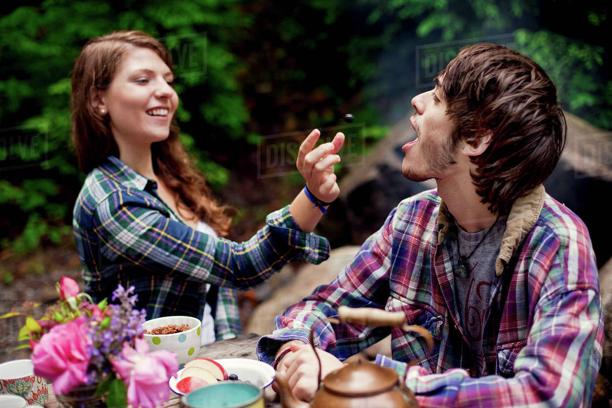 Couple feeding each other in forest Stock Photo Dissolve