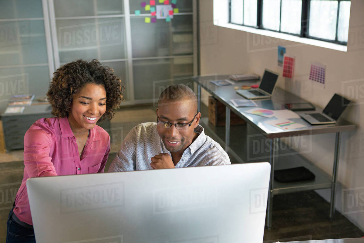 Business people using computer in office - Stock Photo - Dissolve
