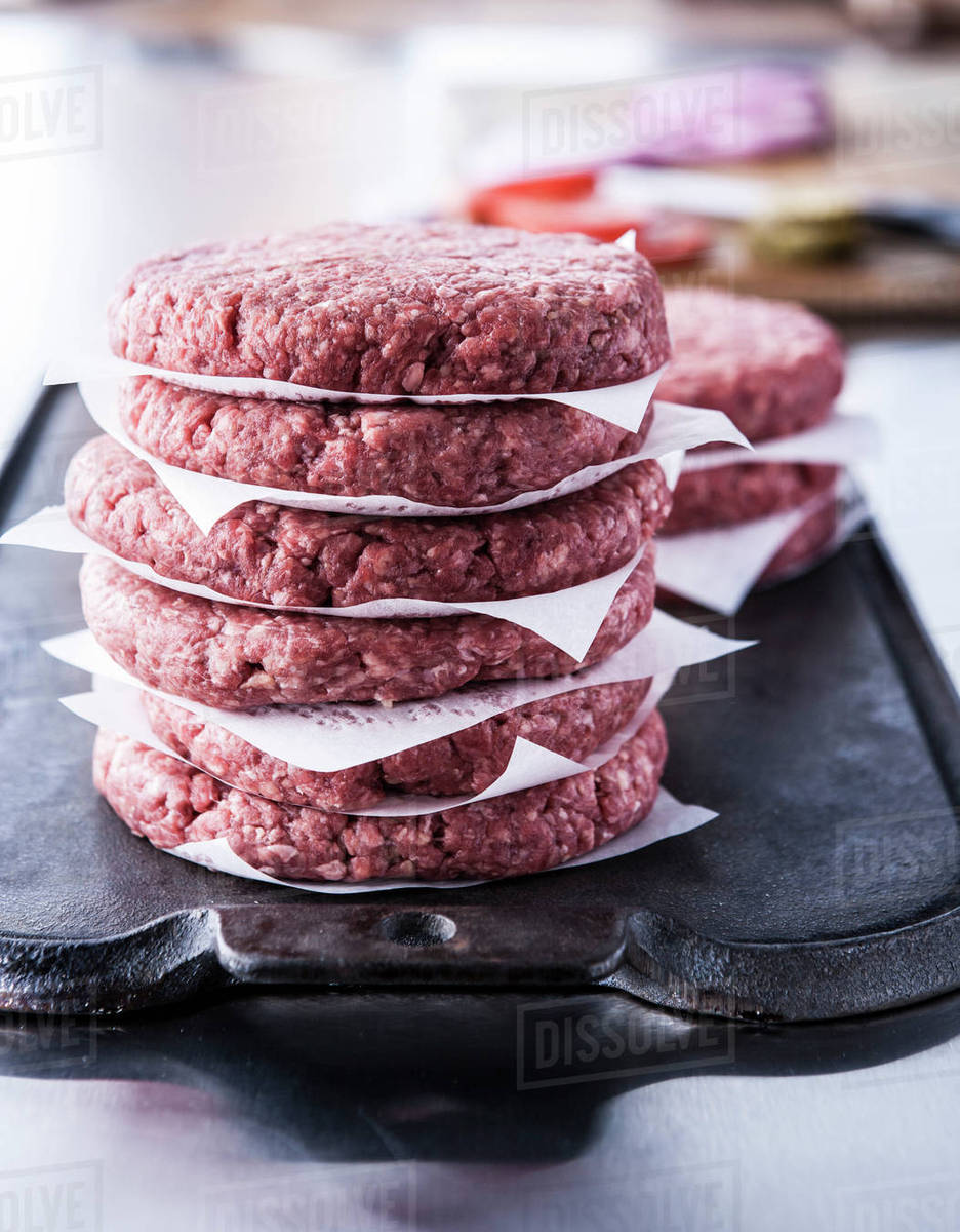 Stack of raw lean ground beef hamburger patties Stock Photo Dissolve