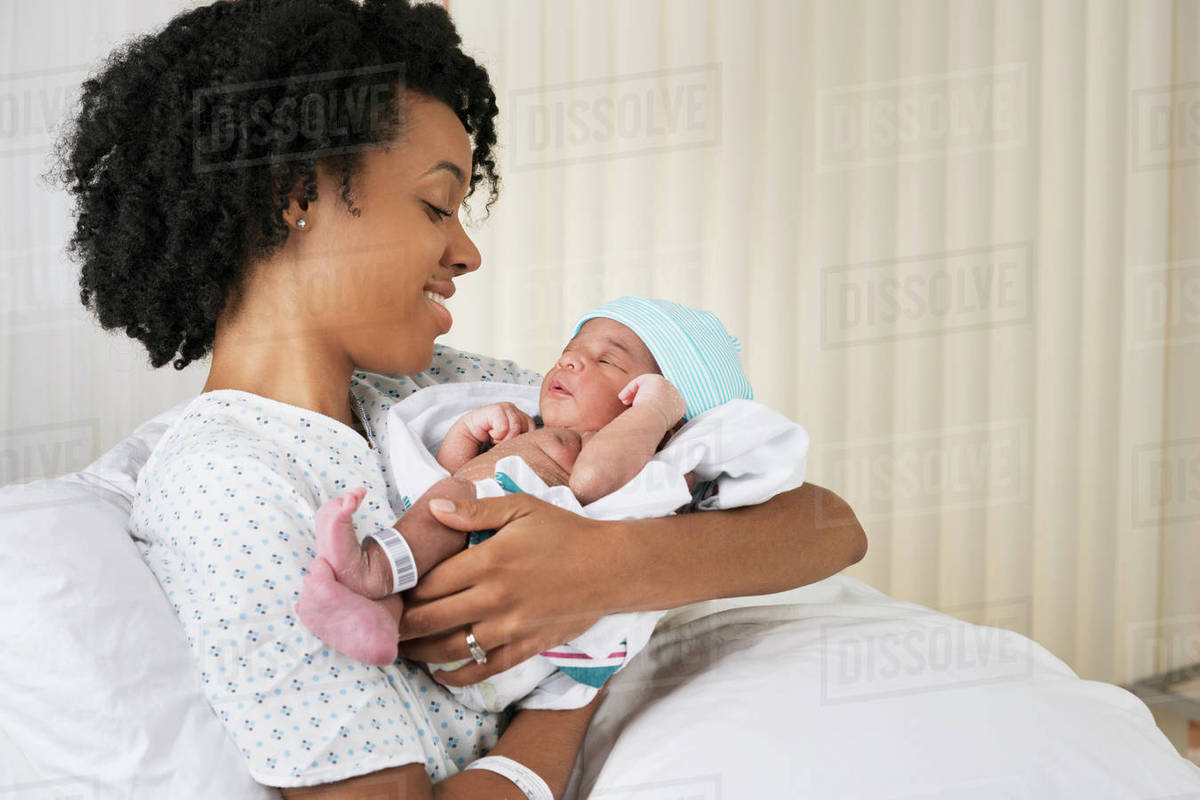 Smiling black mother holding newborn baby in hospital - Stock Photo ...