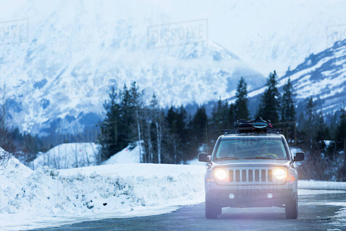 Headlights shining from car driving in winter Stock Photo Dissolve