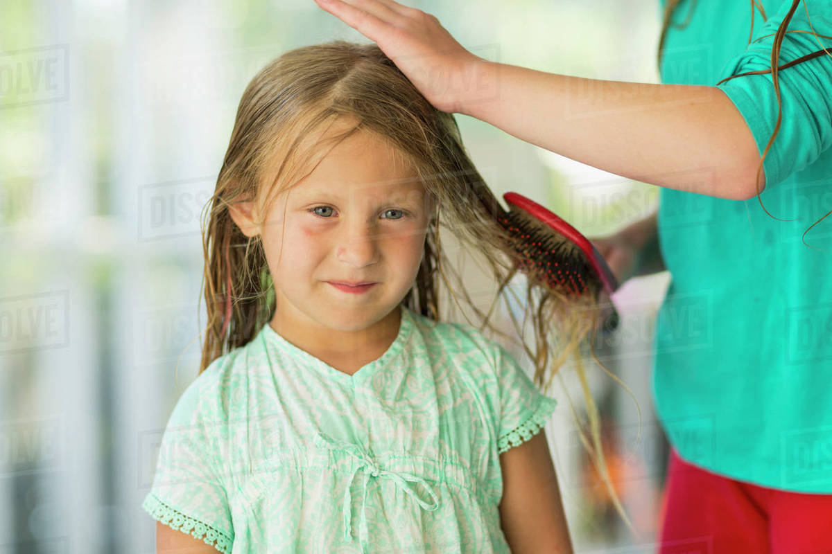 Caucasian girl brushing wet hair of sister Stock Photo Dissolve