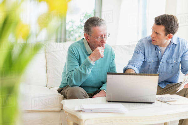 Caucasian man helping father use computer - Stock Photo - Dissolve