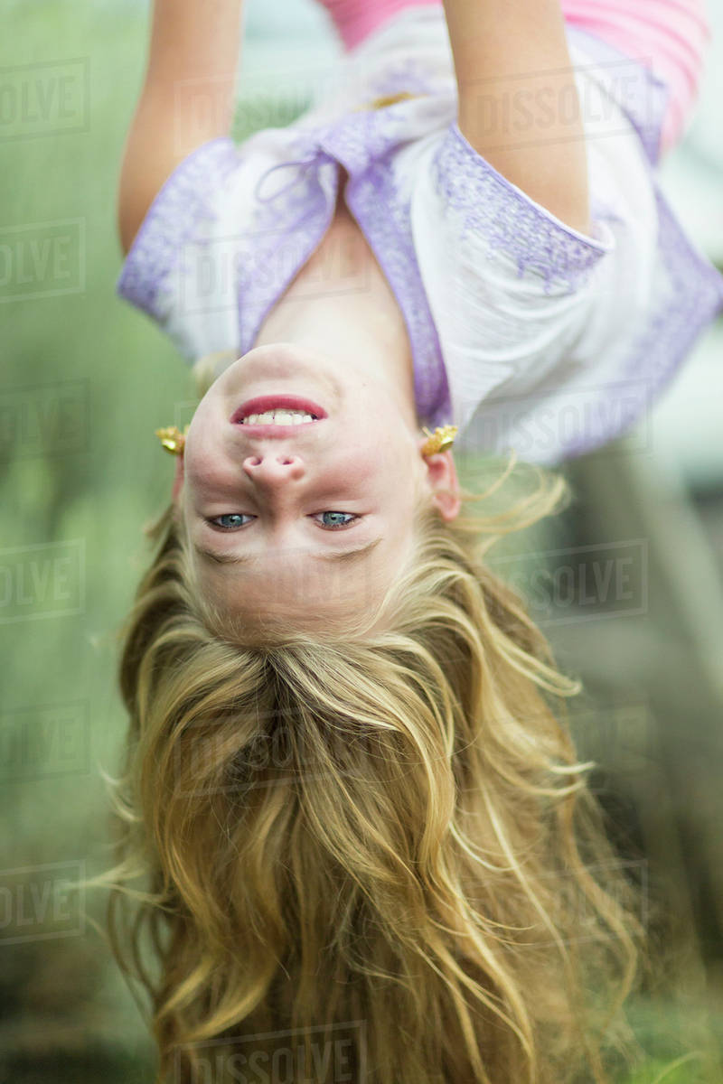 Caucasian Girl Hanging Upside Down Outdoors Stock Photo Dissolve