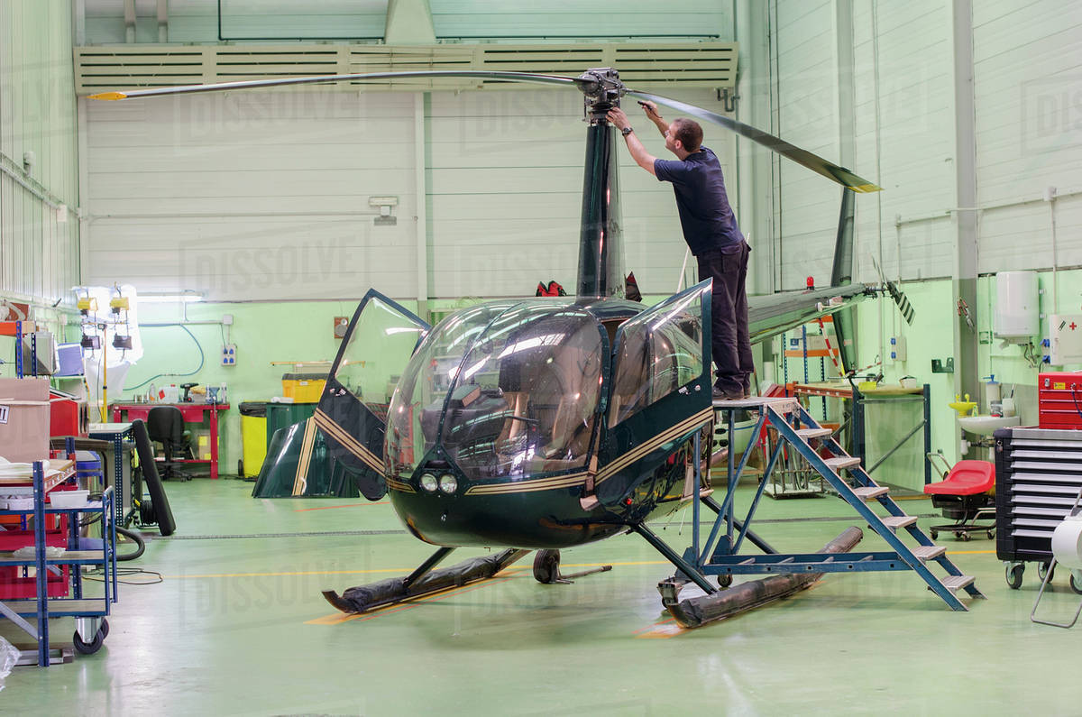 Hispanic mechanic working on helicopter in hangar Royalty-free stock photo