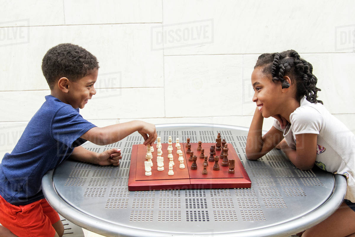 African American brother and sister playing chess - Stock Photo - Dissolve