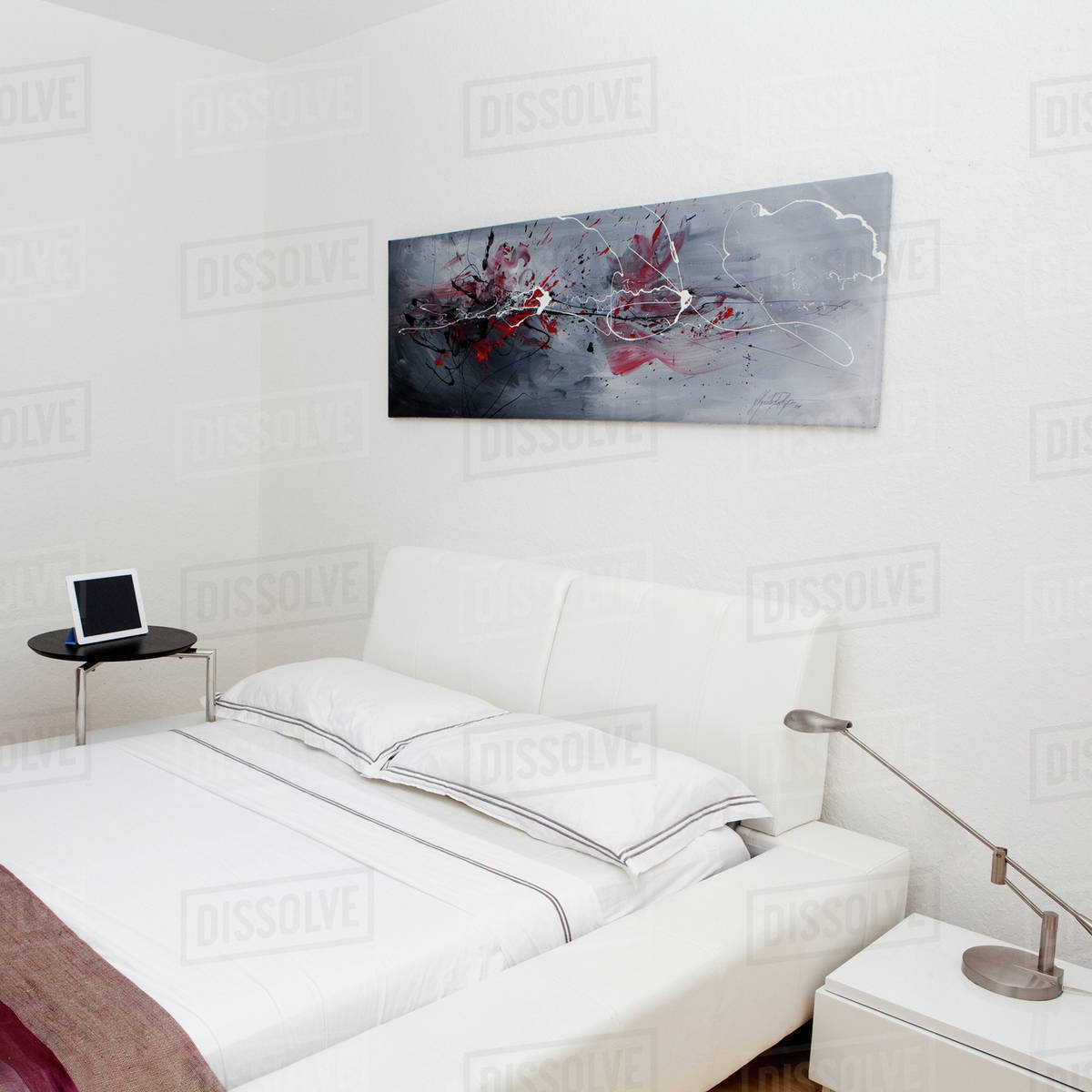 Night table, wall art and bed in modern bedroom - Stock Photo - Dissolve