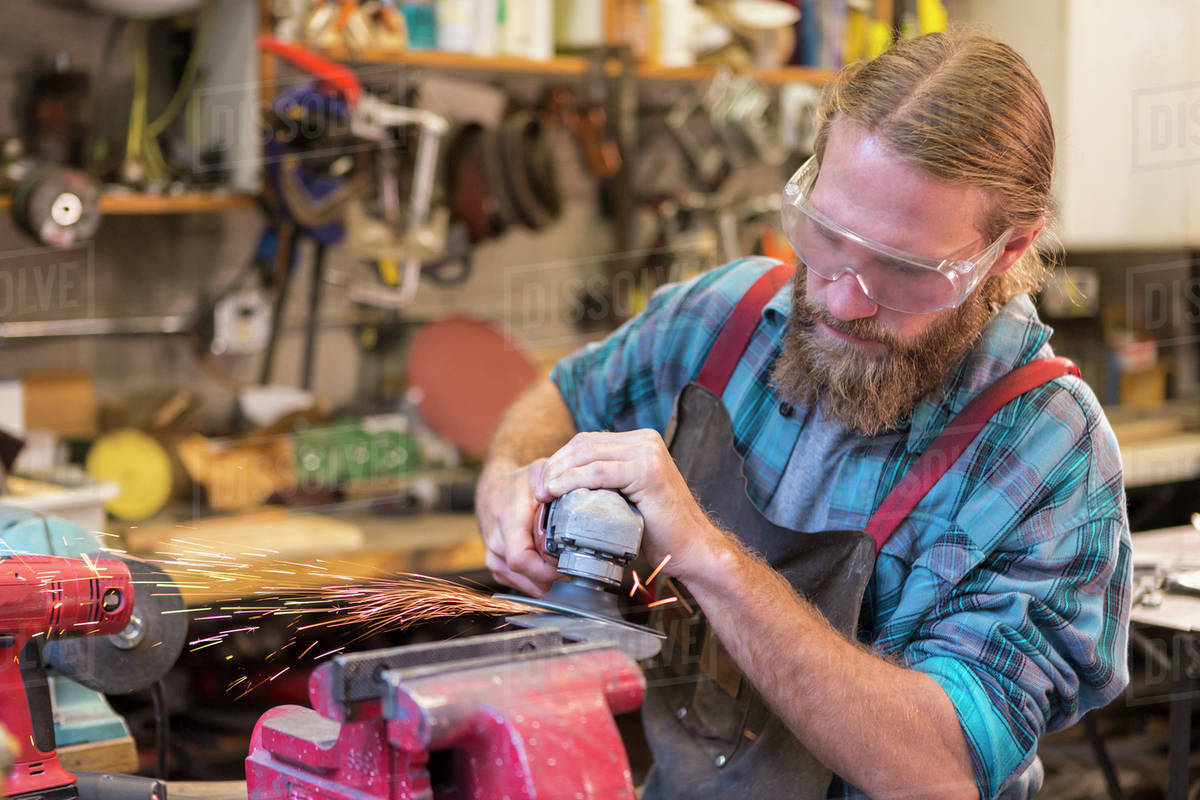 Caucasian craftsman grinding in Stock Photo Dissolve