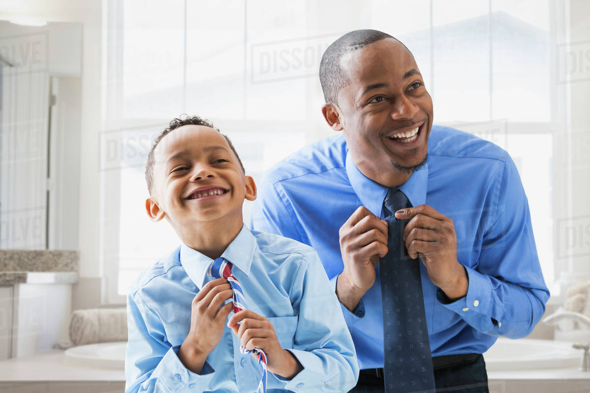 Father and son straightening their ties - Stock Photo - Dissolve