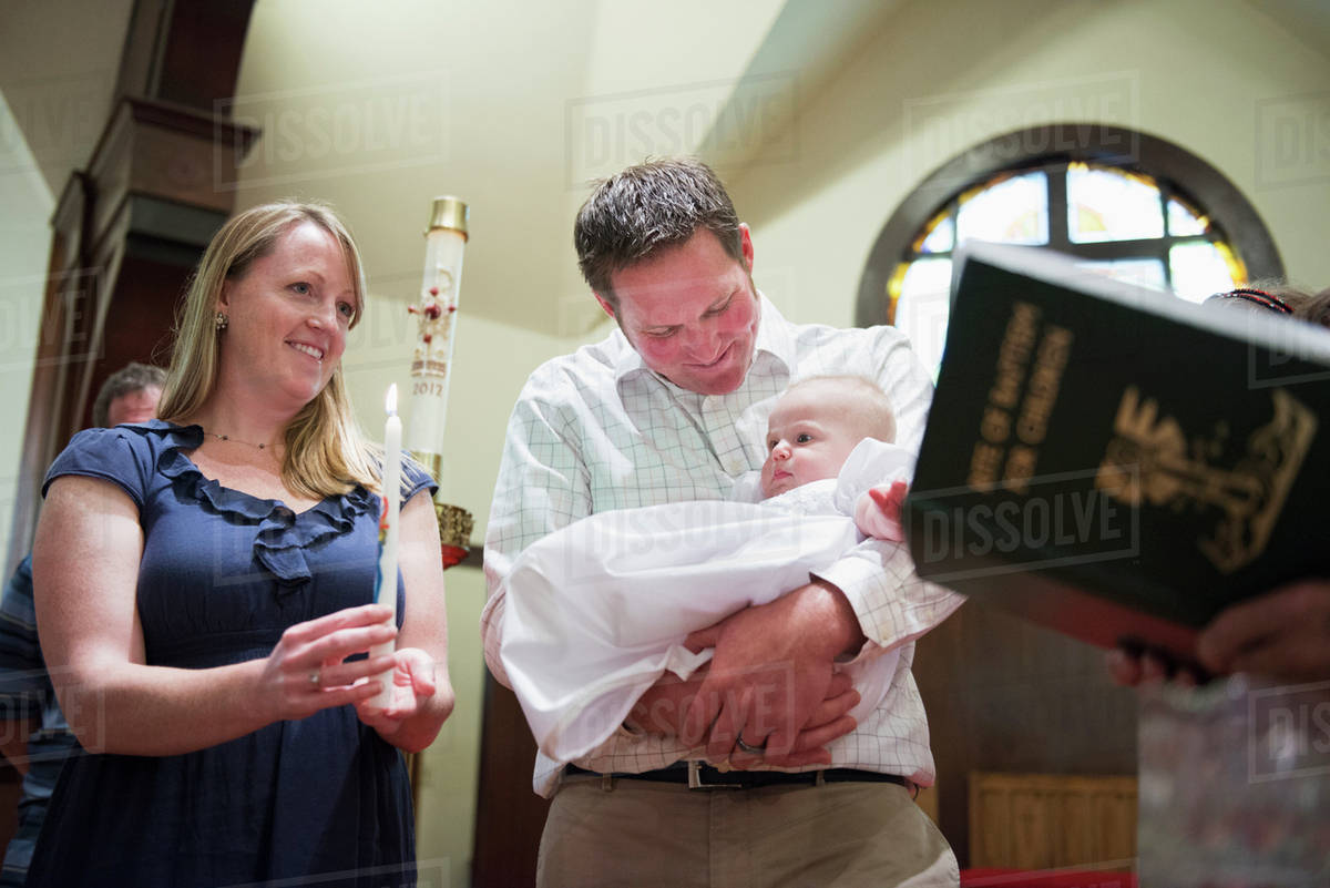 Caucasian parents having baby baptized in church Stock Photo Dissolve