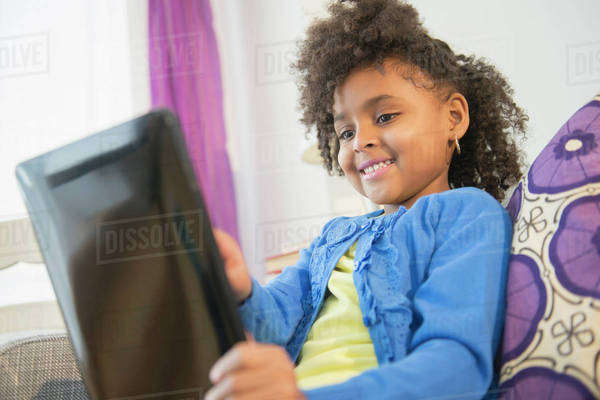 African American girl using tablet computer on sofa - Royalty-free ...