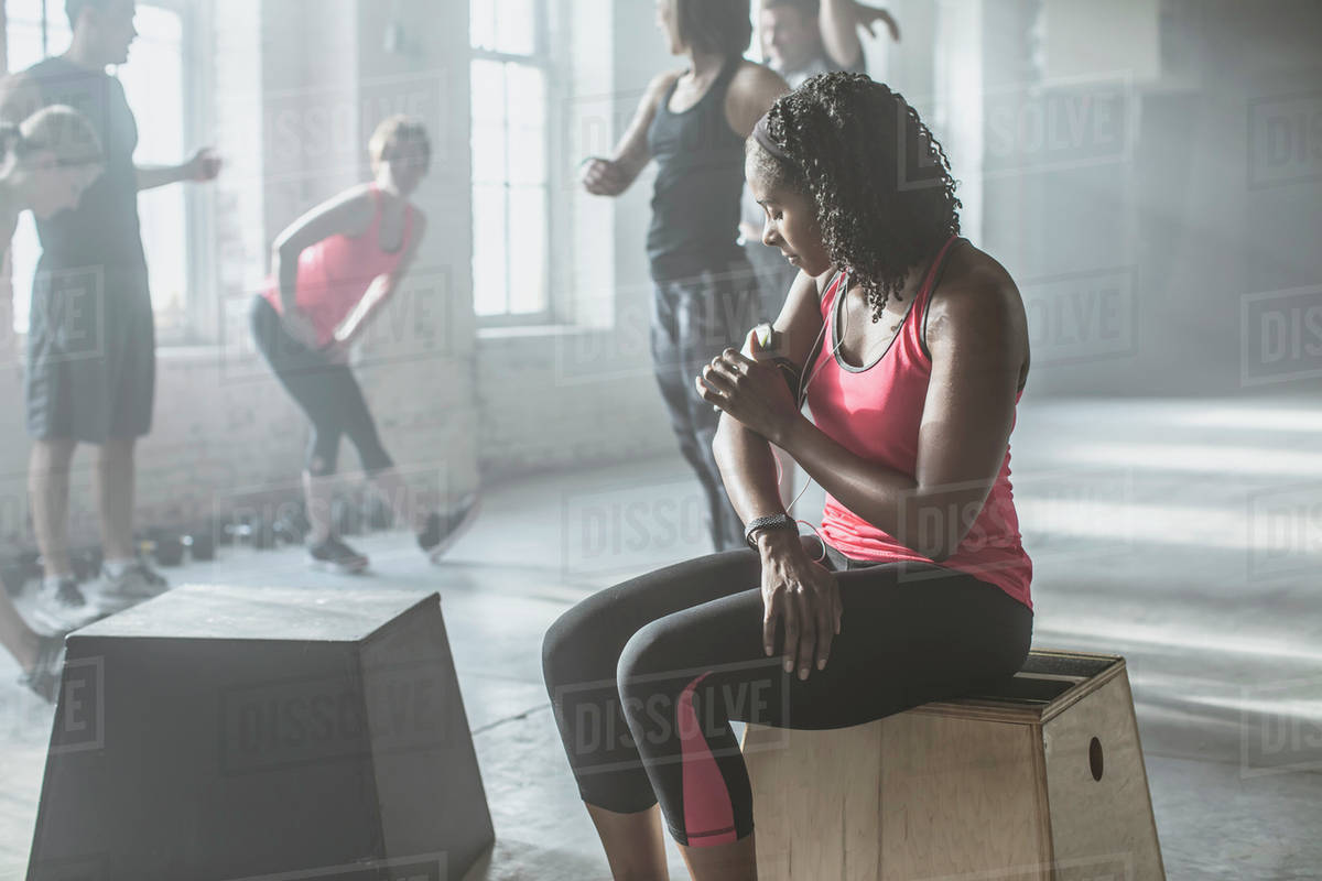 Athlete listening to mp3 player in gym Stock Photo Dissolve
