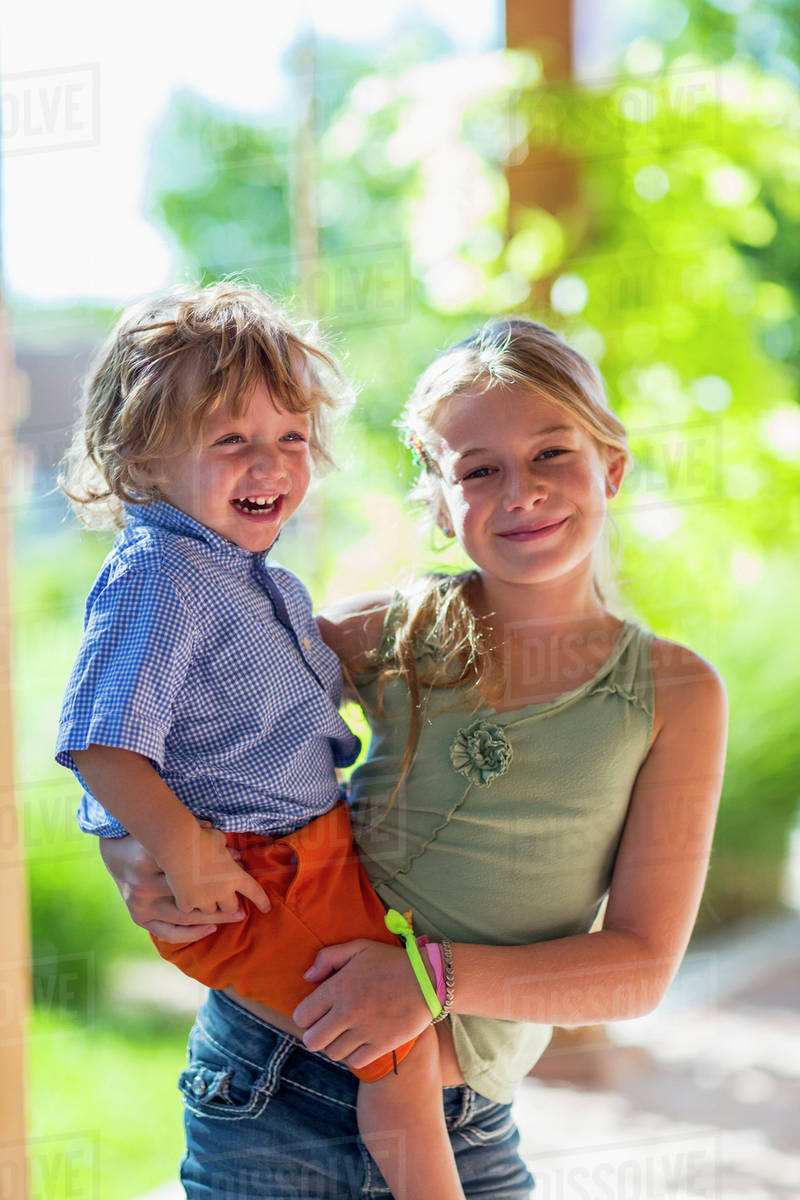 Caucasian girl holding baby brother Stock Photo Dissolve