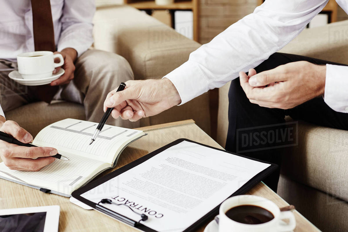Two business colleagues signing a contract during coffee break Stock