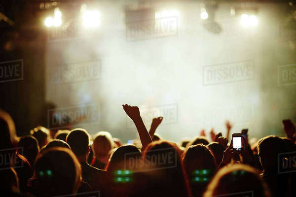 Cheering crowd in front of bright stage lights - Stock Photo - Dissolve