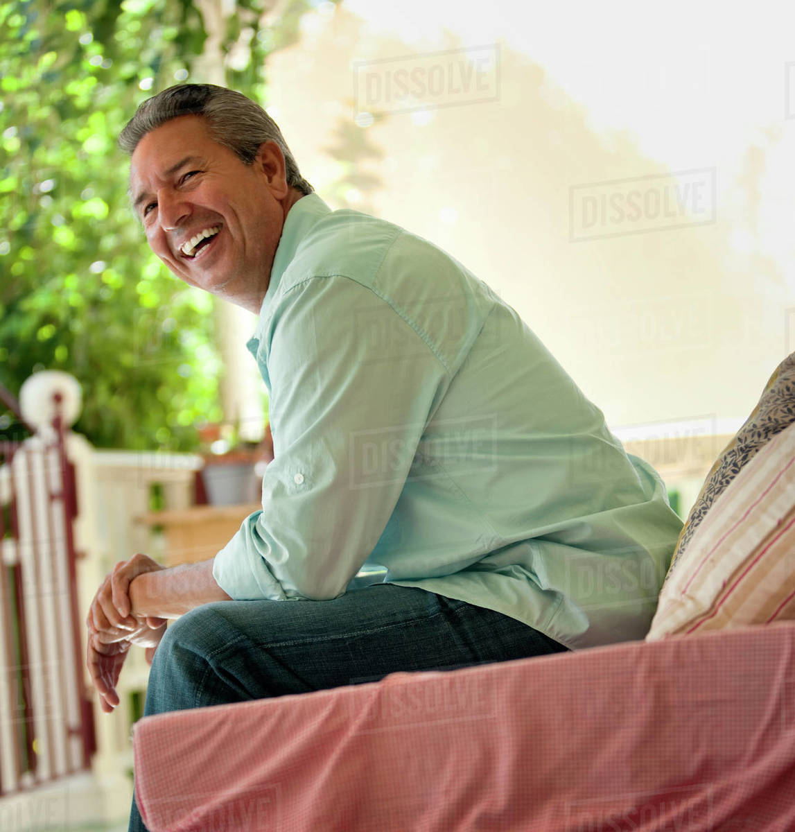 Laughing mature man sitting on the porch. Royalty-free stock photo