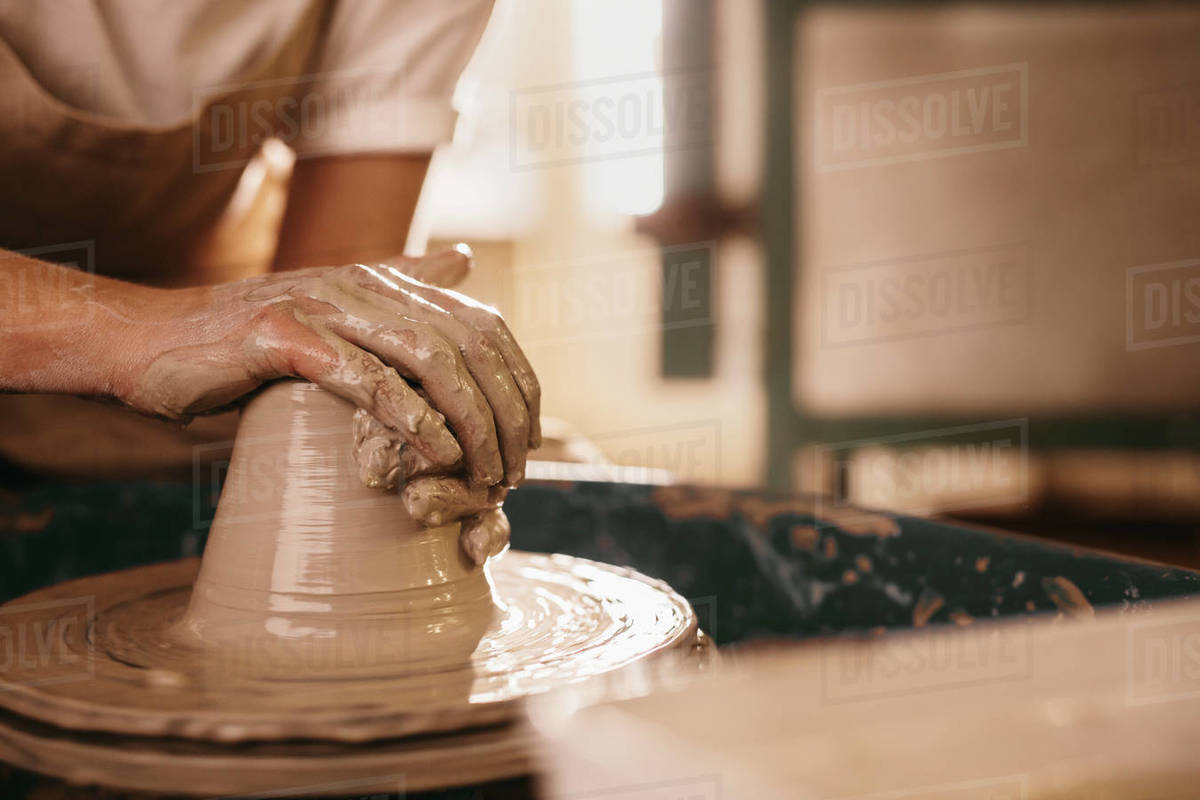 Potter making a clay object on pottery wheel in Craftsman