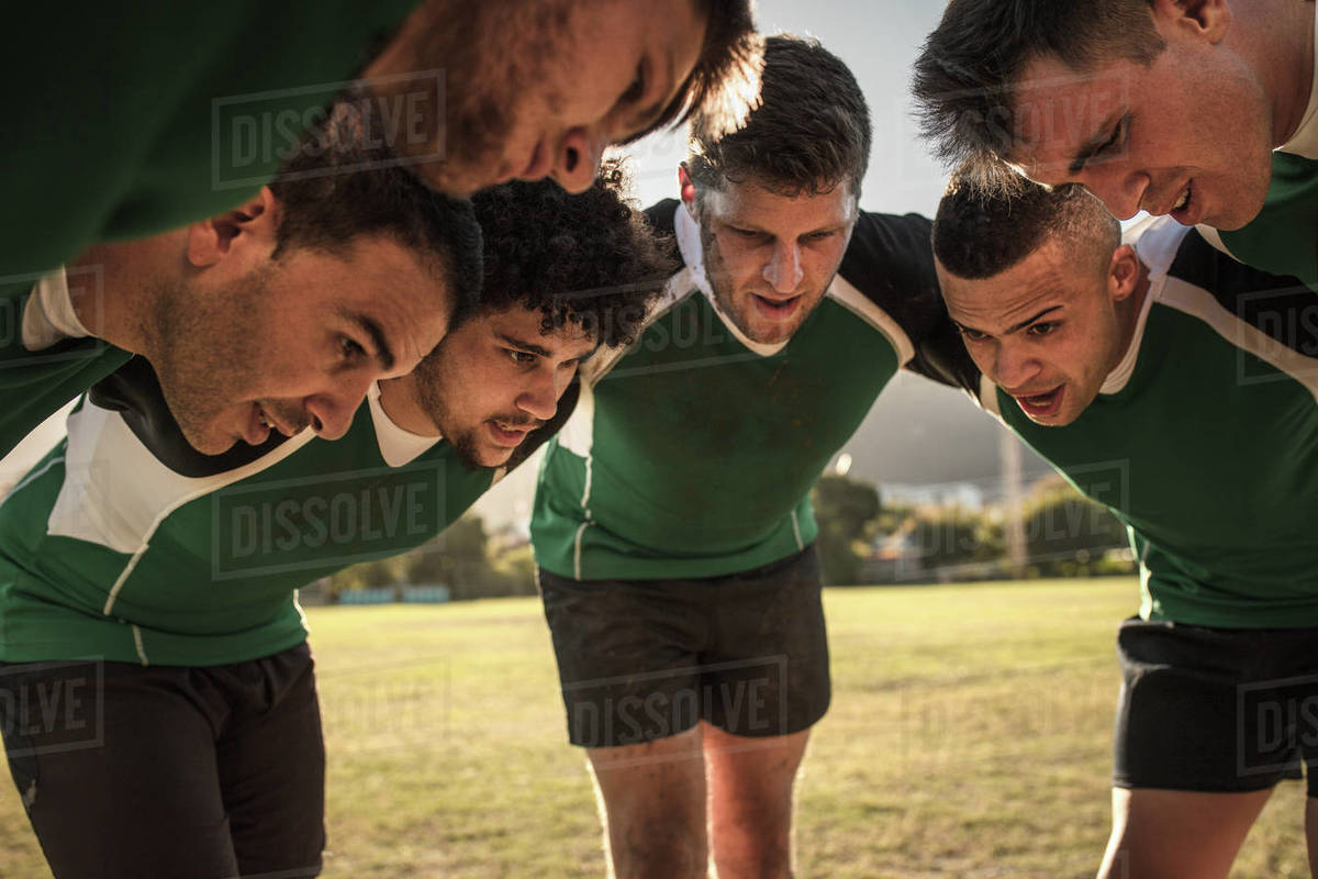 Team of rugby players in huddle discussing their tactics. Professional