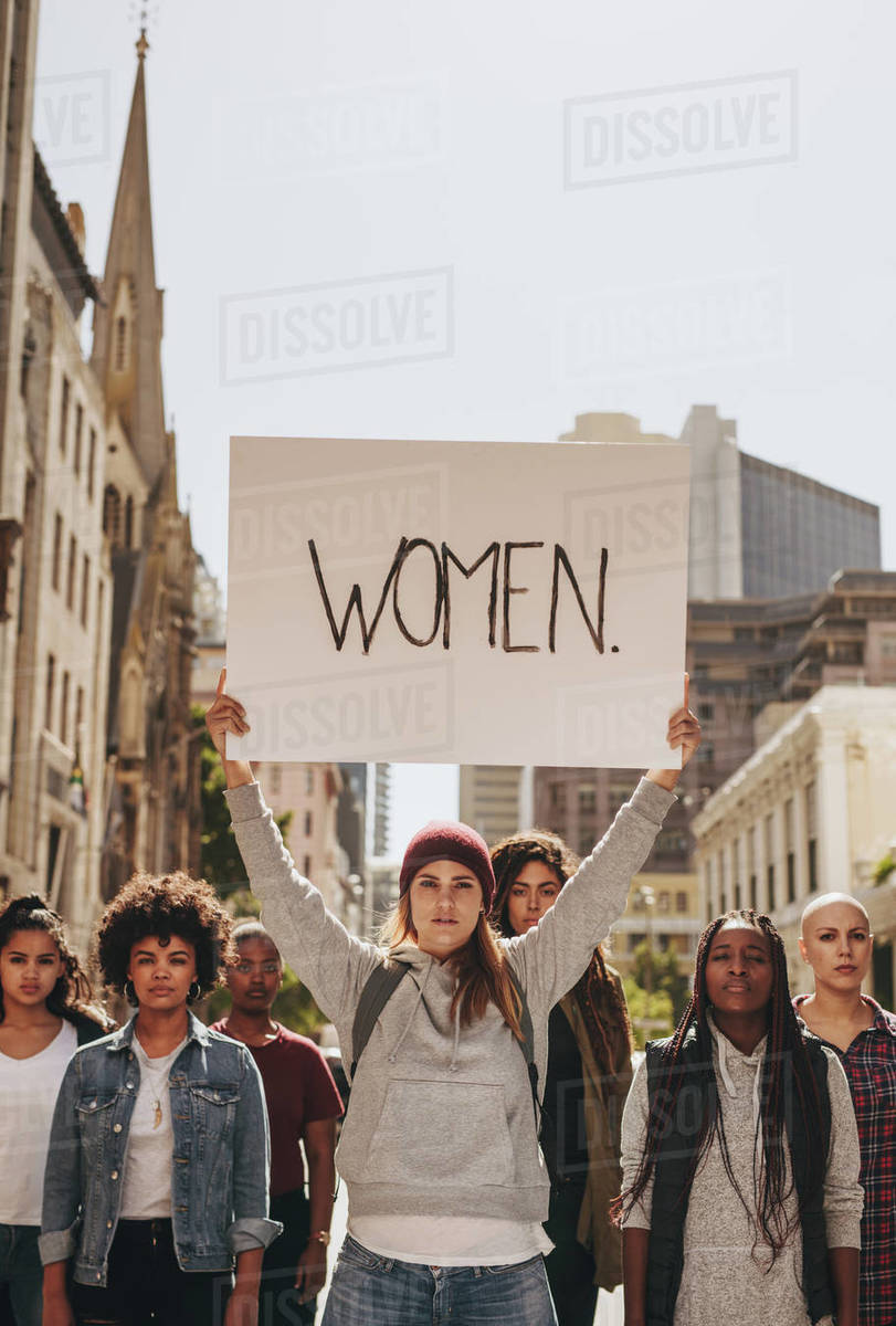 Woman holding a protest sign about women empowerment. Group of women ...