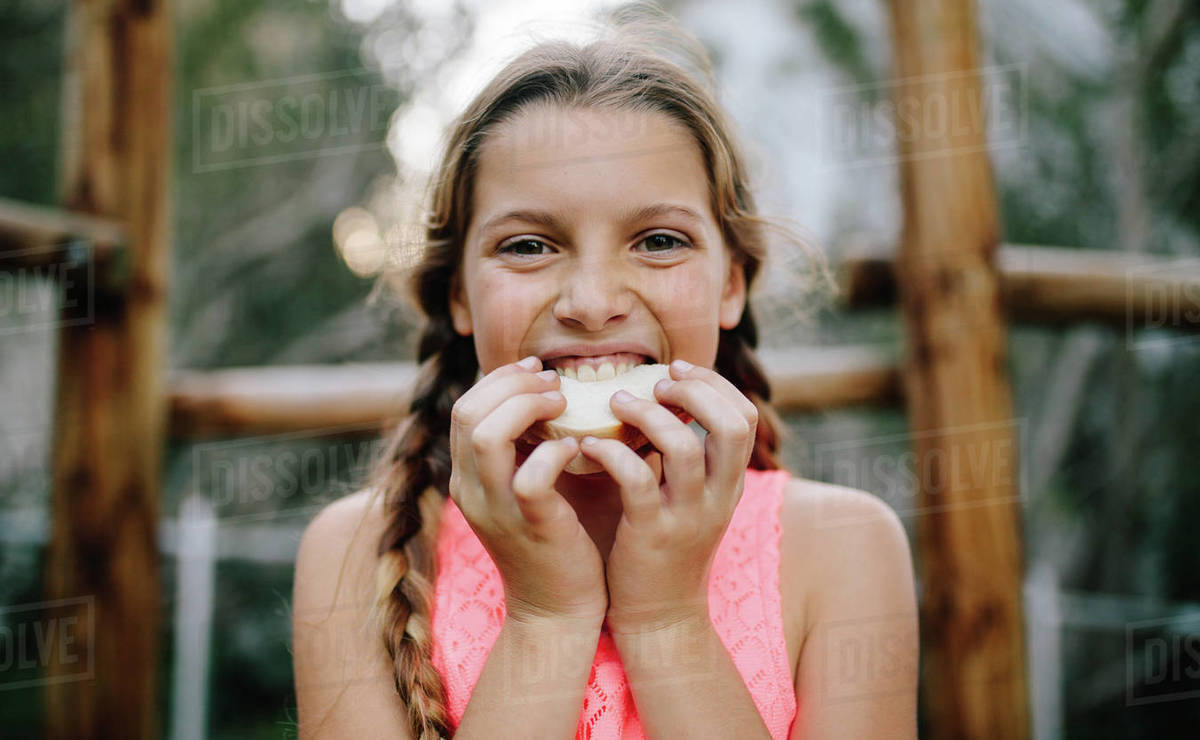 Portrait of a girl eating picnic food outdoors. Close up of a girl