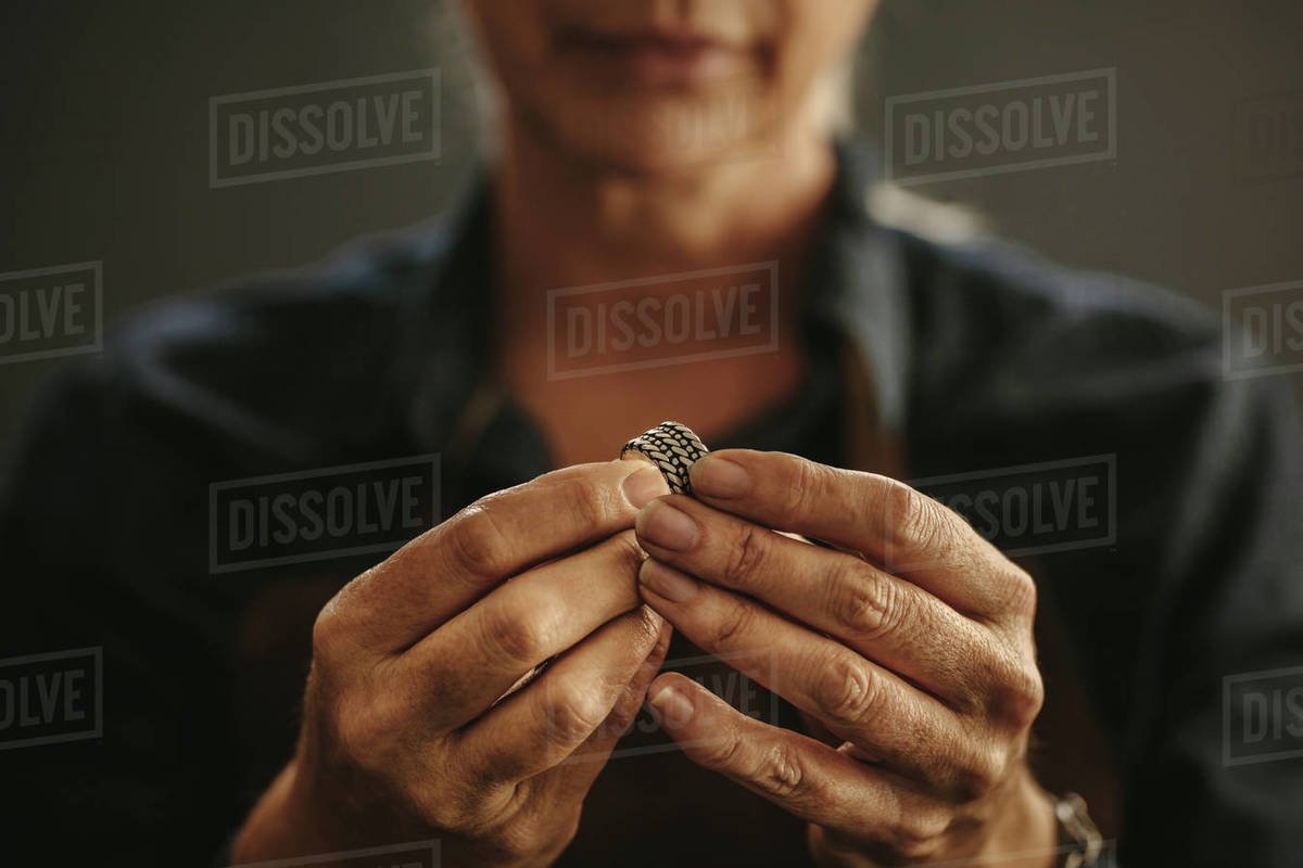 Close up of female jeweler hands examining ring at Focus on