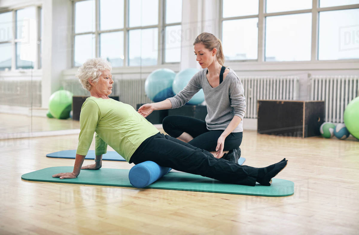 Physical therapist working with active senior woman at rehab. Old woman