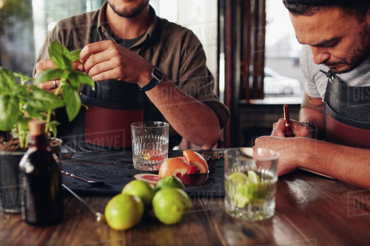 Two bartenders experimenting with creating new cocktails ideas and