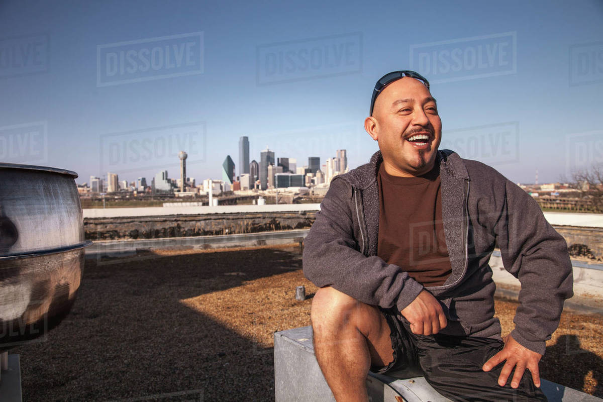 Laughing man sitting on rooftop Royalty-free stock photo