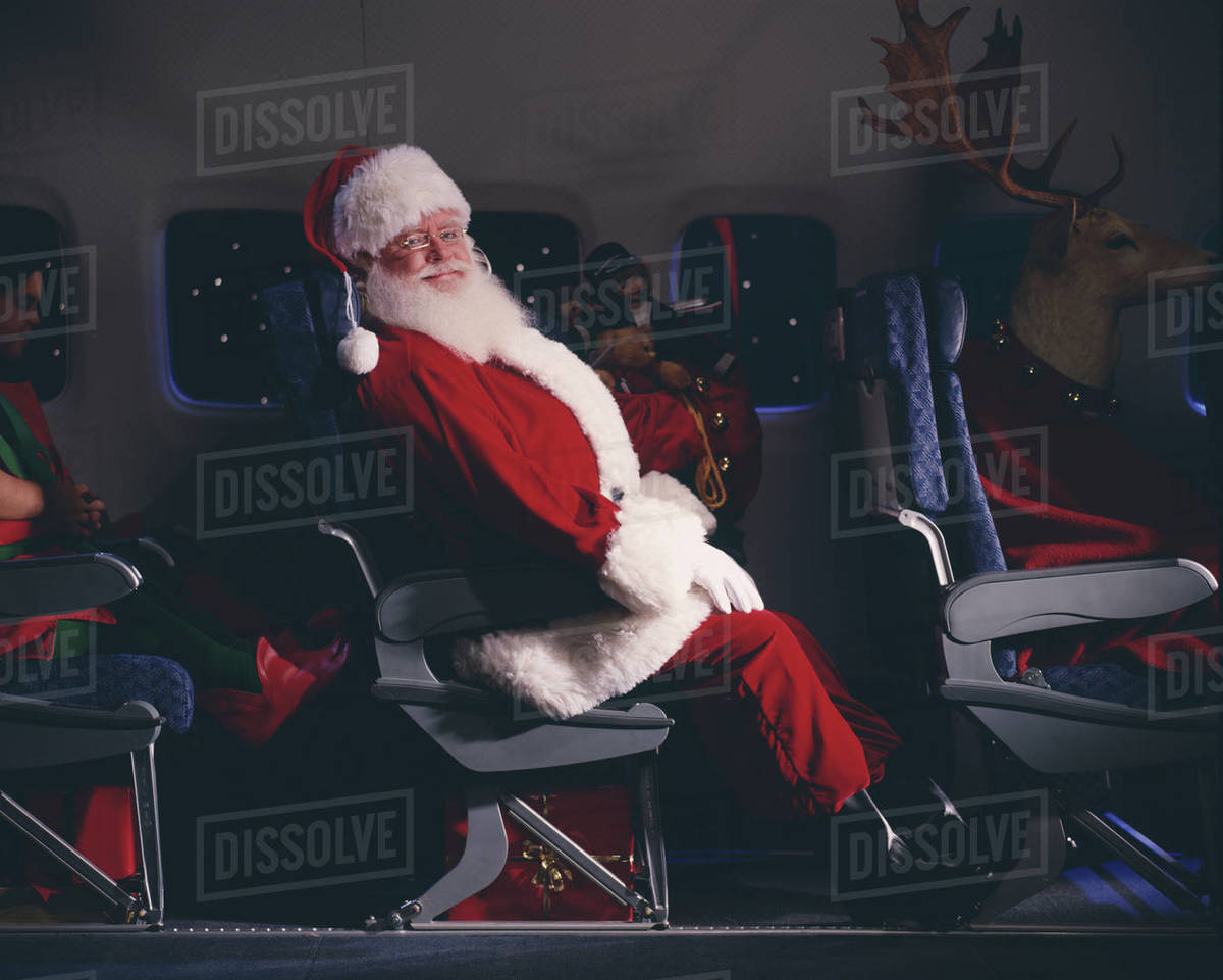 Santa Claus, elves, reindeer and presents on an airplane Royalty-free stock photo