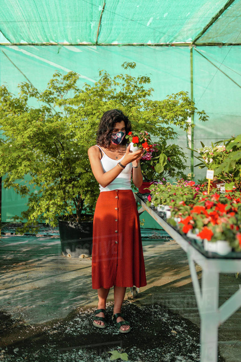 people enjoying nature on Woman With Face Mask Gardening In Greenhouse People Outdoor Activities Enjoying Nature During Pandemic Coronavirus Crises Female With Diy Mask Trought Plants And Flowers Stock Photo Dissolve