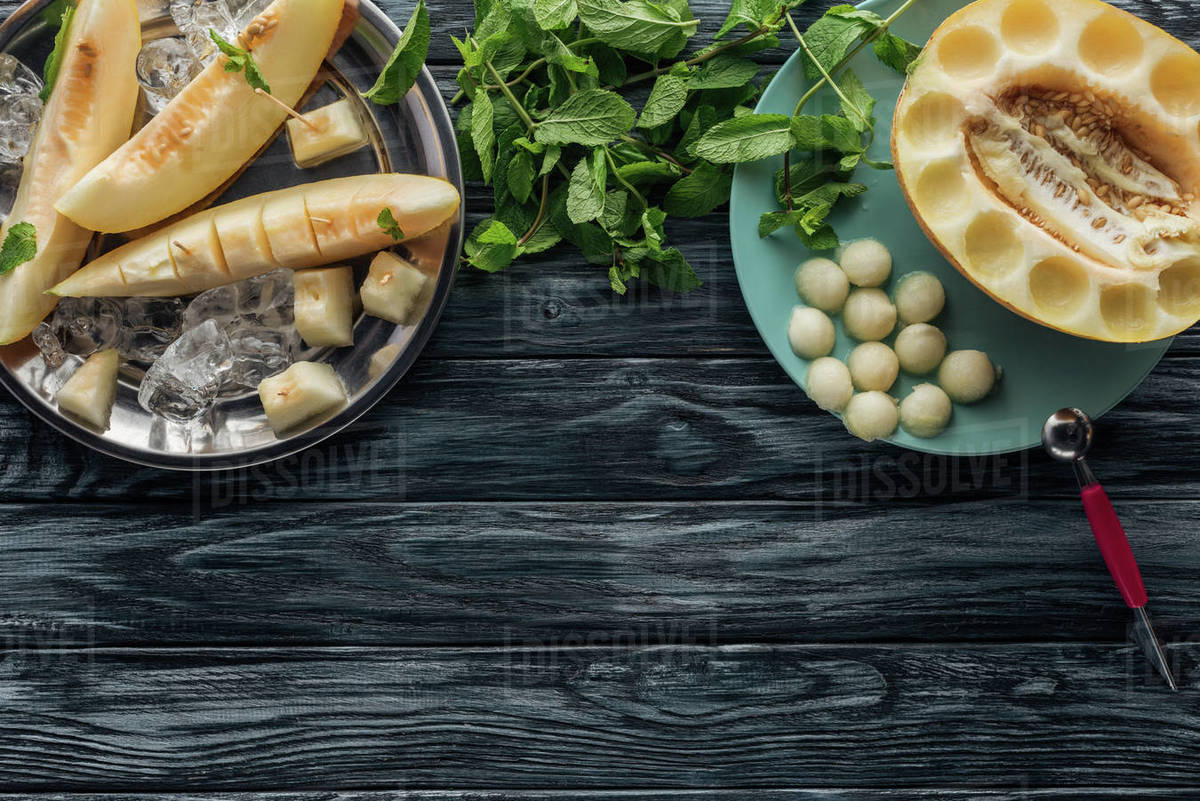 Top view of ripe sweet melon with ice cubes, fresh mint and melon balls
