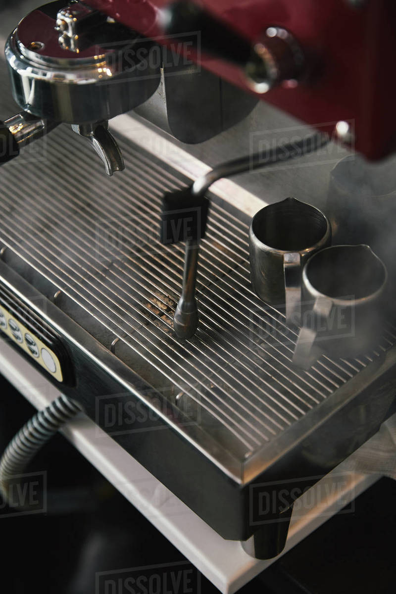 Closeup view of professional coffee machine with steam in coffeehouse