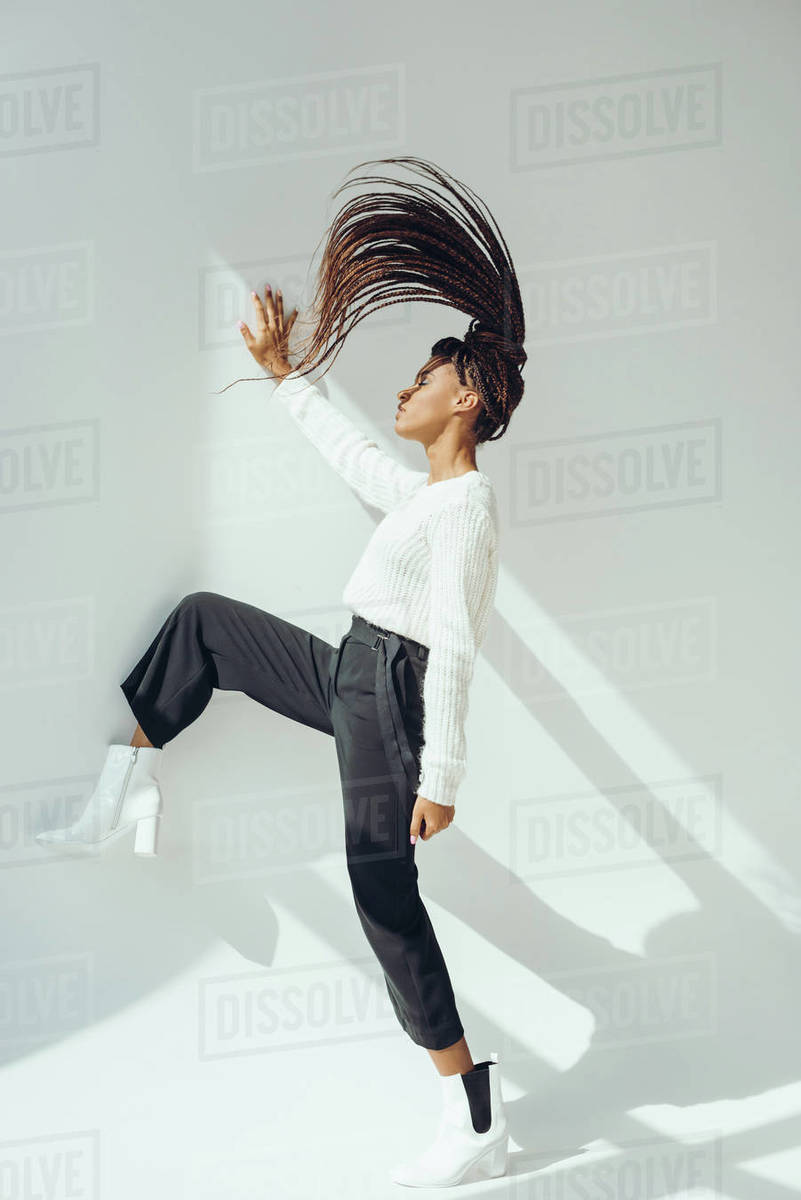 Side view of beautiful stylish African American girl in knitted sweater