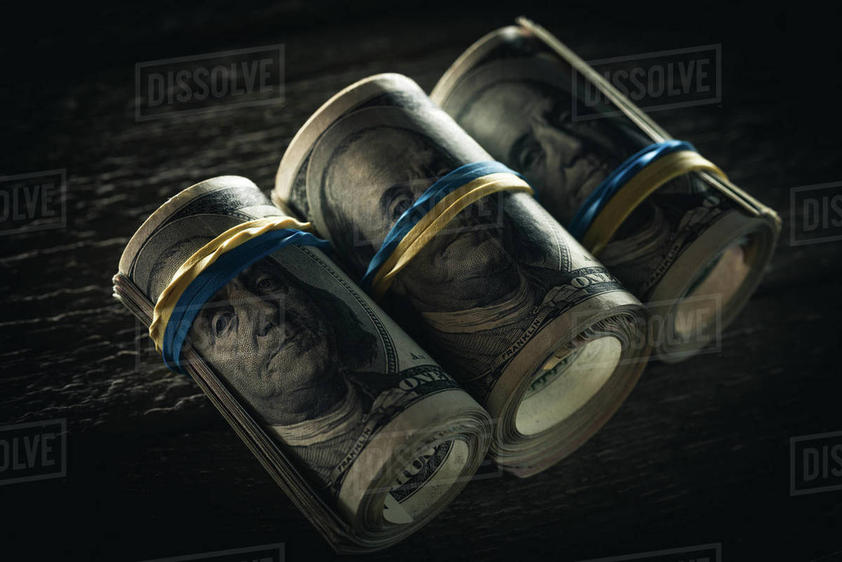 Close up of dollar banknotes in rolls with rubber bands Stock Photo